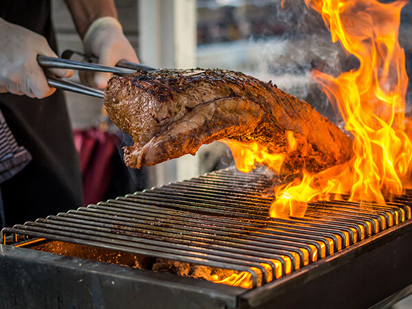 Beispielbild Grill, Flammen schlagen hoch, Steak wird gewendet - Handwerk